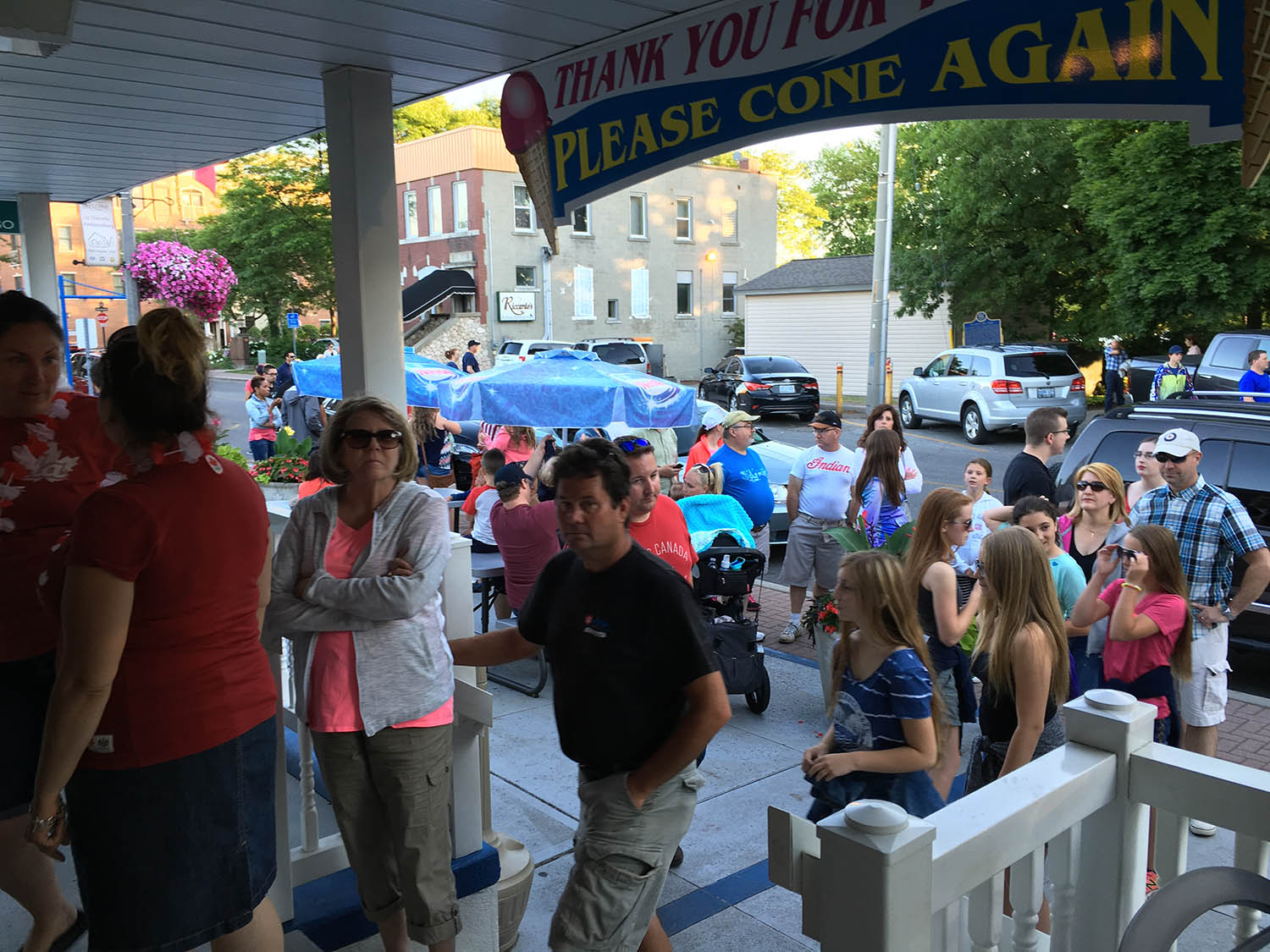 A crowd of people sitting on the sidewalk.