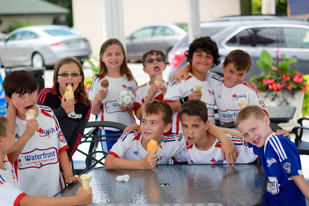 A group of children sitting at a table eating food.