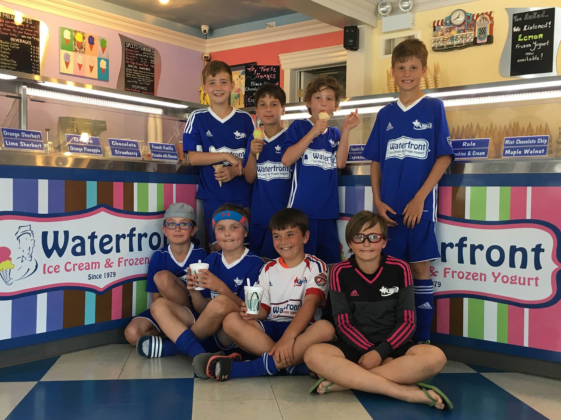 A group of young boys in blue and white soccer uniforms.