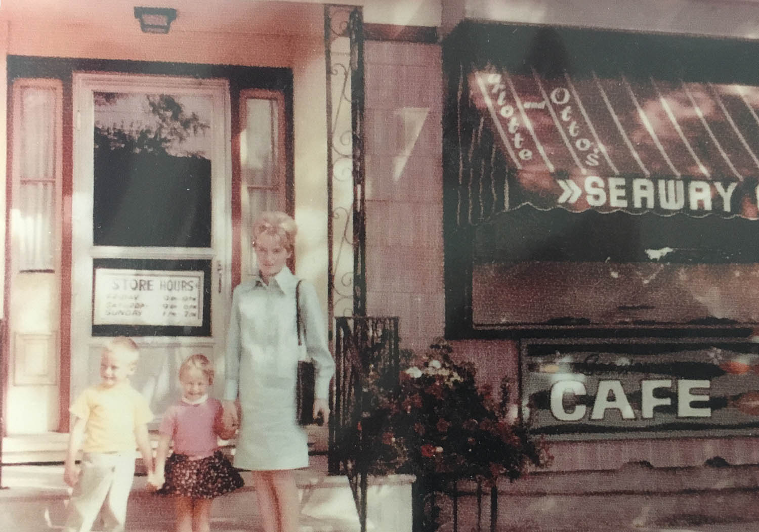 A woman and two children standing in front of a building.